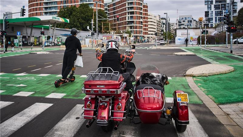 Ein Mann fährt auf seinem Motorrad mit seinem Hund in Tel Aviv, Israel.