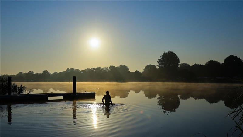 Ein Mann geht am frühen Morgen in der Eider schwimmen.