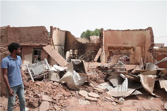 Ein Mann geht an einem Haus in Khartum vorbei, das bei den jüngsten Kämpfen im Sudan getroffen wurde.