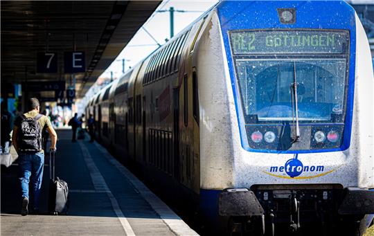 Ein Mann geht einen Bahnsteig im Hauptbahnhof entlang.
