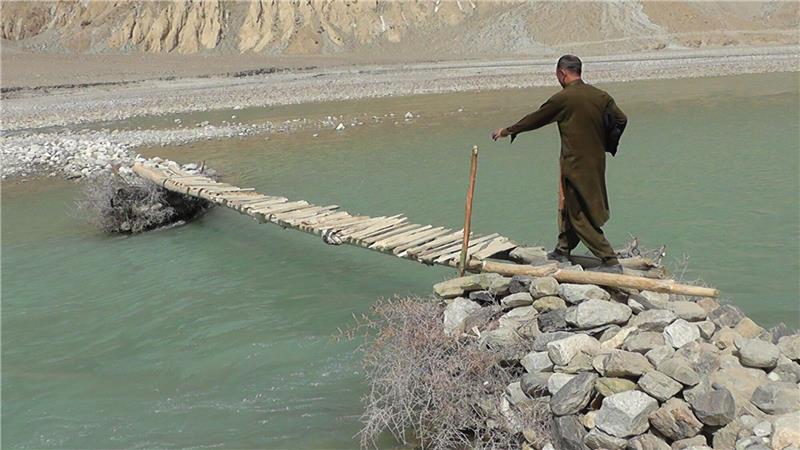 Ein Mann geht über eine hölzerne Brücke im Norden Pakistans nahe der afghanischen Grenze. Sturzfluten im hatten im vergangenen Jahr eine Brücke weggespült.