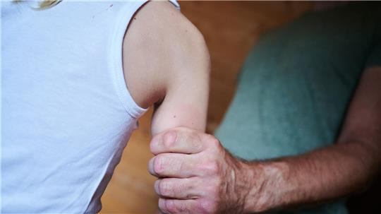 Ein Mann hält ein Kind fest am Arm (gestellte Szene). (Symbolbild)