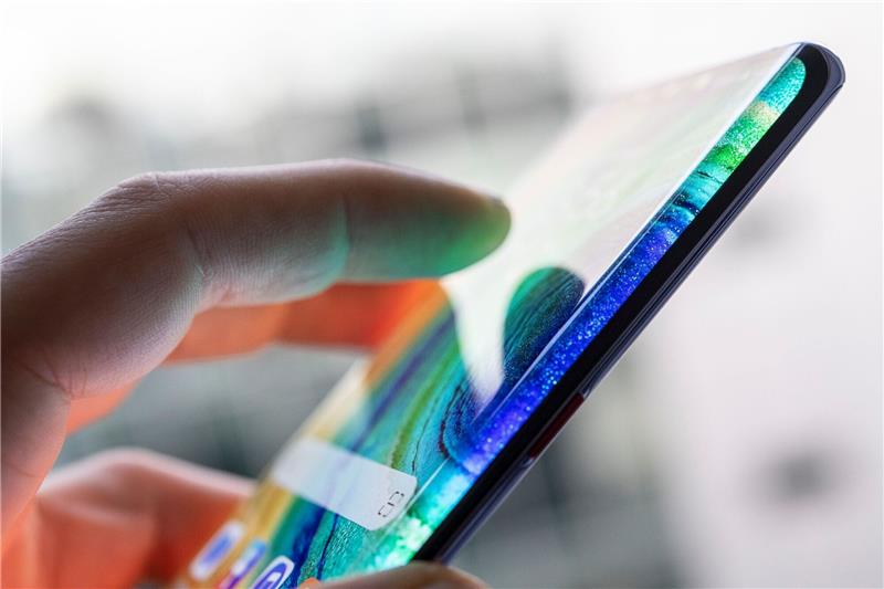 Polizisten unter Beschuldigten bei Chat-Ermittlungen Ein Mann hält ein Smartphone in der Hand.