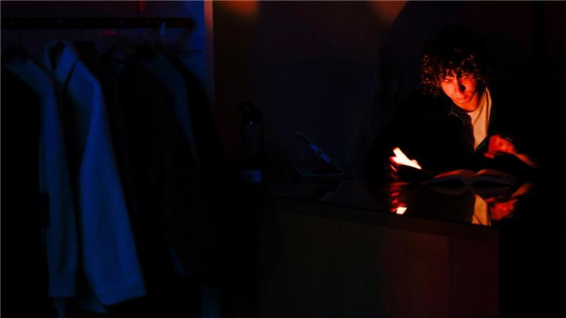 Ein Mann liest während des Stromausfalls in San Francisco bei Kerzenlicht.