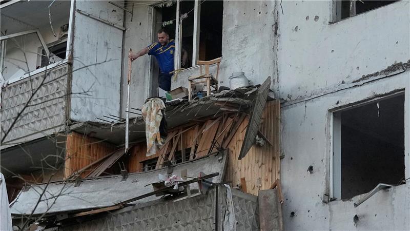 Ein Mann räumt in Kiew Trümmer an seinem Wohnhaus raus, das nach einem russischen Raketeneinschlag beschädigt wurde.