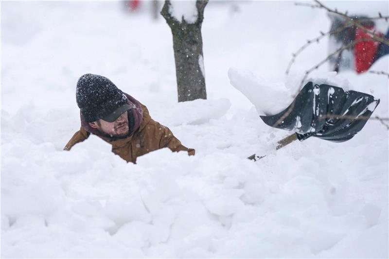 Mehr als 50 Tote nach Schneechaos in den USA Ein Mann schaufelt seine Einfahrt frei.