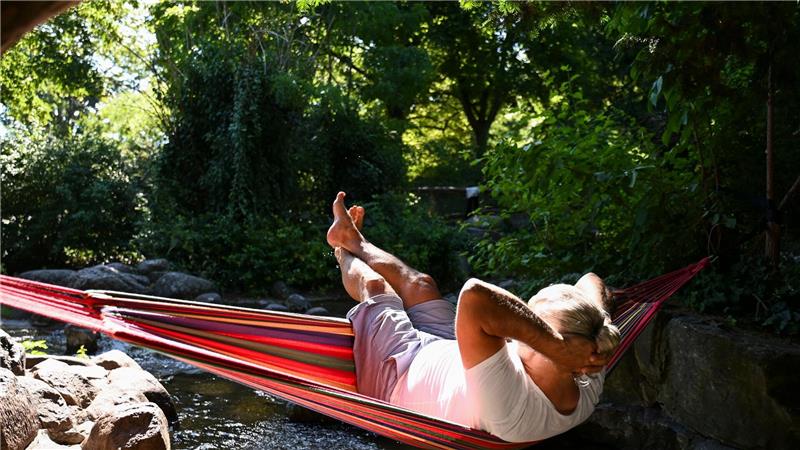 Heißester Tag des Jahres - Unwetter beenden die Hitzewelle Ein Mann schaukelt im Berliner in einer Hängematte über dem Wasser.