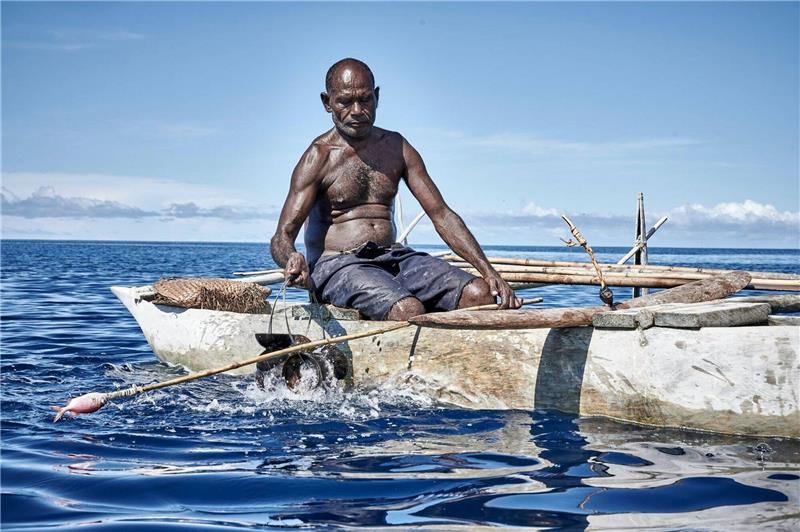 Ein Mann sitzt beim «Shark Calling Festival» in einem Boot. Auf der Insel vor Papua-Neuguinea rufen Einheimische gefährliche Haie mit Liedern und Rasseln.