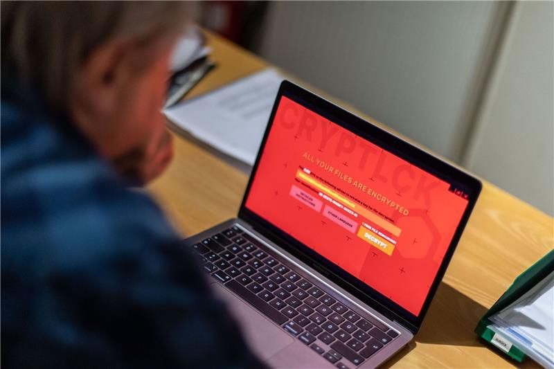Internetuser sehen sich von Cyberkriminalität bedroht Ein Mann sitzt vor einem Laptop, der mit einem Verschlüsselungstrojaner (Ransomware) befallen ist.