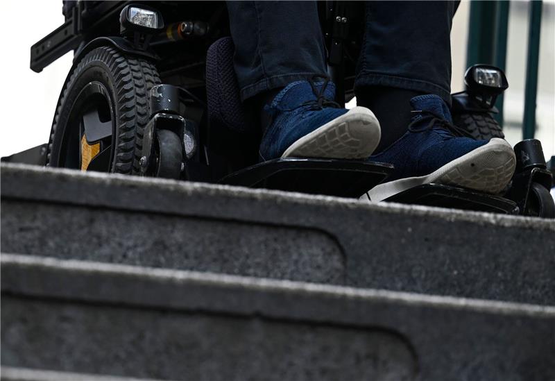 Abgeordnete mit Behinderungen vernetzen sich Ein Mann steht mit seinem Rollstuhl vor der Treppe eines Eingangs zur U-Bahn.
