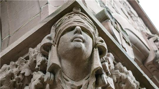 Ein Mann stirbt unerwartet im Amtsgericht Oldenburg. Eine Skulptur der Justitia hängt an einer Säule an dessen Eingang. (Symbolbild)