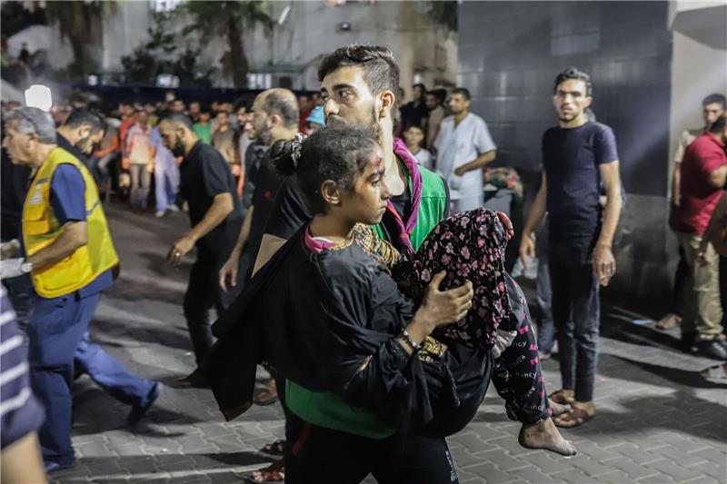 Wut in Nahost über Explosion bei Gaza-Klinik Ein Mann trägt nach dem Raketeneinschlag ein verletztes Mädchen.
