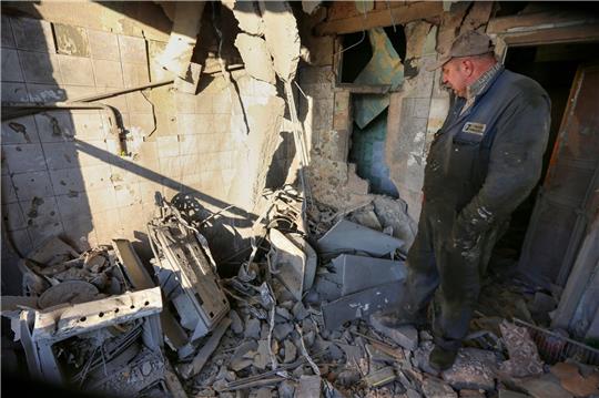 Ein Mann untersucht ein durch Beschuss beschädigtes Wohnhaus. Die Ukraine meldet erneut neue Raketenangriffe.