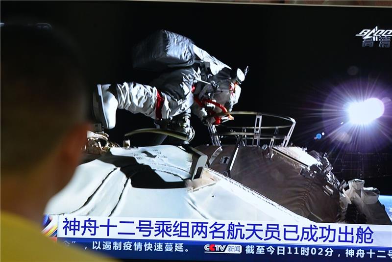 Drei chinesische Astronauten sicher aus All zurück Ein Mann verfolgt vor dem Fernseher die Live-Übertragung eines Außeneinsatzes an der Raumstation «Tiangong» (Archivbild).