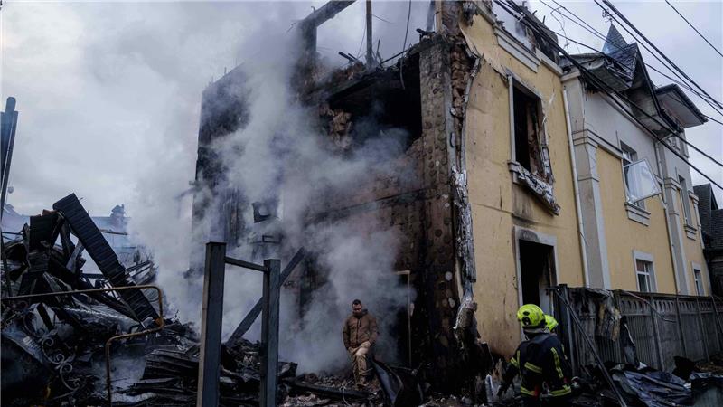 Ein Mann verlässt in Kiew ein zerstörtes Haus.