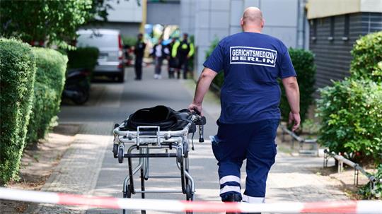 Ein Mann von der Gerichtsmedizin schiebt eine Bahre in der Nähe des Fundortes des toten Neugeborenen.