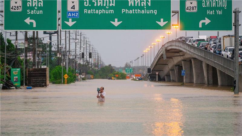 Ein Mann watet durch die Fluten in einem Vorort von Hat Yai in Thailand.