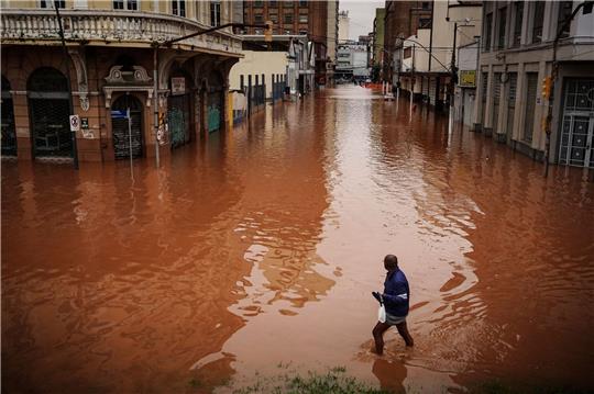 Ein Mann watet in Porto Alegre im brasilianischen Bundesstaat Rio Grande do Sul durch ein von schweren Regenfällen überschwemmtes Gebiet.