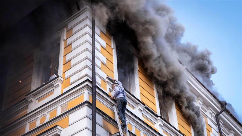 Ein Mann wird mithilfe einer Rettungsleiter aus einem brennenden Gebäude der Nationalen Akademie der Wissenschaften evakuiert, das durch einen russischen Drohnenangriff beschädigt wurde.