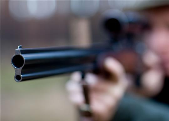 Ein Mann zielt mit einem Jagdgewehr.