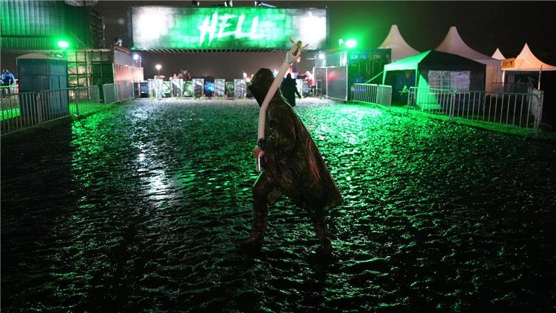 Bilder des Tages Ein Metal-Fan verlässt in der Nacht das Festivalgelände des Wacken Open Air.