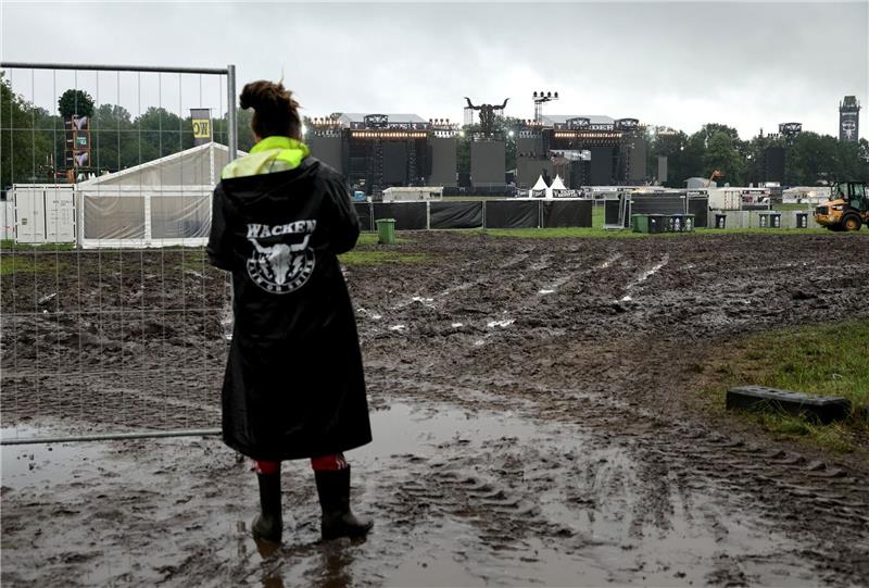 Metalfans feiern in Wacken, aber nicht alle dürfen rein Ein Metal-Fan vor einem noch geschlossenen Einlass zu den beiden Hauptbühnen auf dem vom Regen aufgeweichten Festivalgelände.