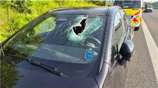 Ein Metallteil trifft die Windschutzscheibe: Der Fahrer wird verletzt.