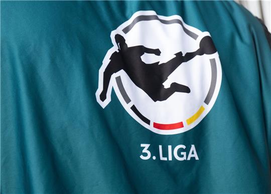 Ein Mitarbeiter der Fernsehproduktion trägt ein Leibchen mit dem Logo der 3. Liga.