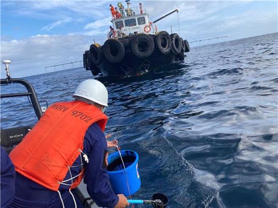 Ein Mitarbeiter der Küstenwache übernimmt  Wasserproben, nachdem ein vor der Küste der Philippinen gesunkener Tanker Öl verloren hat.