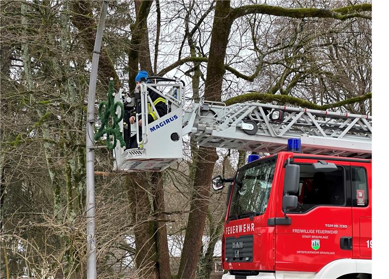 Ein Mitarbeiter der Städtischen Betriebe nimmt die Weihnachtsbeleuchtung vom Korb der Feuerwehr-Drehleiter aus ab. Foto: Eggers
