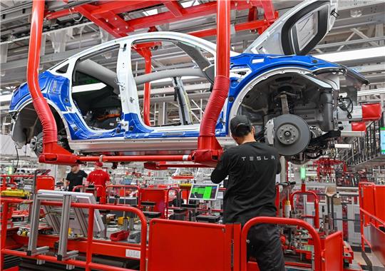 Ein Mitarbeiter der Tesla Gigafactory in Brandenburg. Der Autobauer hat dem Land ein starkes Wachstum beschert.