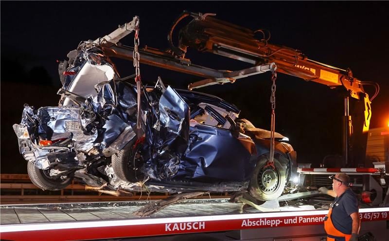 Polizei: Details zum schweren Unfall auf der A14 Ein Mitarbeiter eines Abschleppunternehmens verlädt das Wrack eines Pkw nach einem schweren Verkehrsunfall auf der Autobahn 14 bei Halle-Trotha.