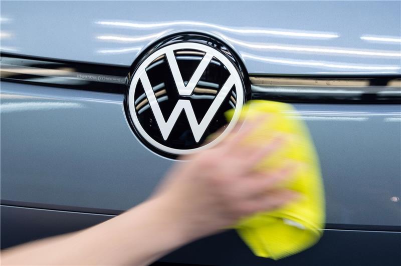 Emden: Bauernproteste bringen Produktion bei VW zum Erliegen Ein Mitarbeiter von Volkswagen streicht mit einem Tuch über ein Fahrzeug von VW.