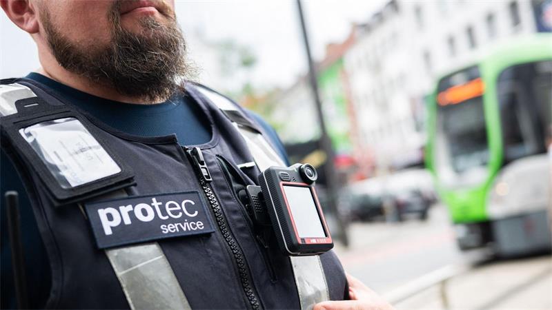 Ein Mitarbeiter von protec steht mit einer Bodycam vor einer einfahrenden Stadtbahn. Der Sicherheitsdienstleiter protec – eine Tochter der hannoverschen Verkehrsbetriebe Üstra – erprobt sie in einem Pilotprojekt.