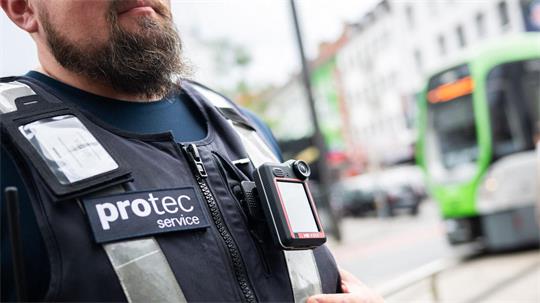 Ein Mitarbeiter von protec steht mit einer Bodycam vor einer einfahrenden Stadtbahn. Der Sicherheitsdienstleiter protec – eine Tochter der hannoverschen Verkehrsbetriebe Üstra – erprobt sie in einem Pilotprojekt.
