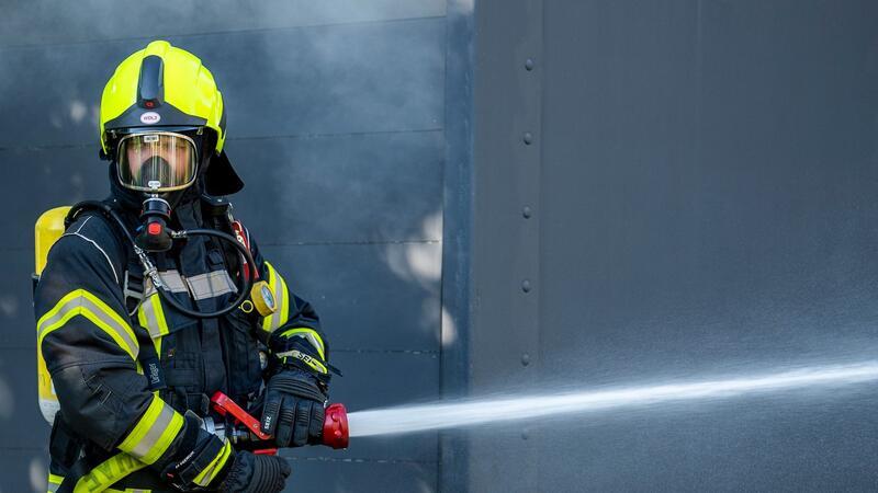 Löscharbeiten nach Brand in Lagerhalle abgeschlossen Ein Mitglied der Feuerwehr beim Löscheinsatz.