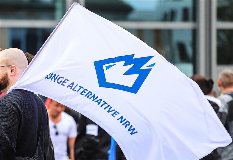 NRW-Verfassungsschutz: AfD-Nachwuchs ist Verdachtsfall Ein Mitglied der «Jungen Alternative» (JA) trägt auf einer Wahlkampfveranstaltung in Dortmund eine Fahne mit dem Logo der Organisation.
