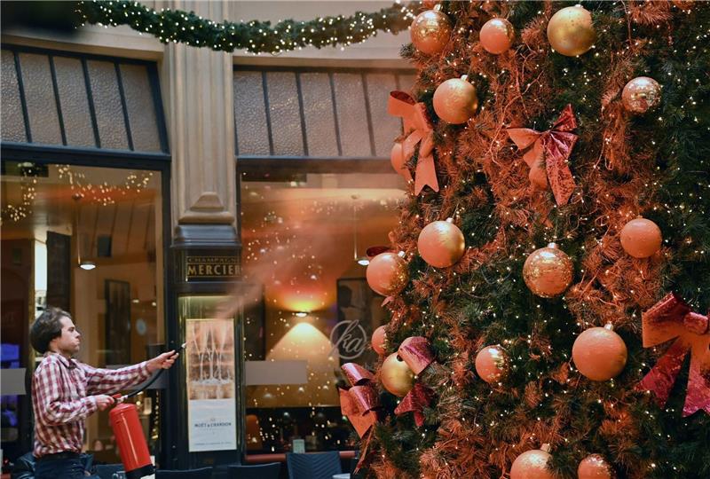 Klimaschützer besprühen Weihnachtsbäume mit oranger Farbe Ein Mitglied der Protestgruppe "Letzte Generation" besprüht einen Weihnachtsbaum in der Leipziger Mädler-Passage.