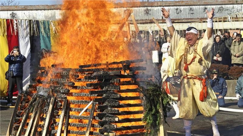Ein Mönch wirft Glücksbringer und Amulette als Dank in ein Feuer.