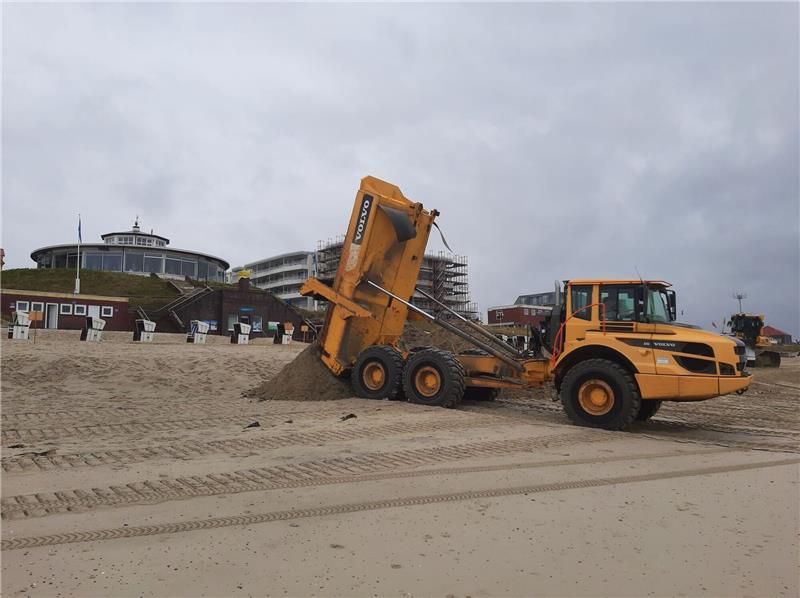 Ein Muldenkipper schüttet am Badestrand der ostfriesischen Insel Wangerooge fehlenden Sand auf.