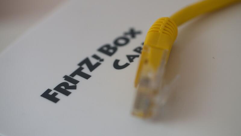 Ein Netzwerkkabel liegt auf einem Fritz!-Box-Router der Firma AVM.