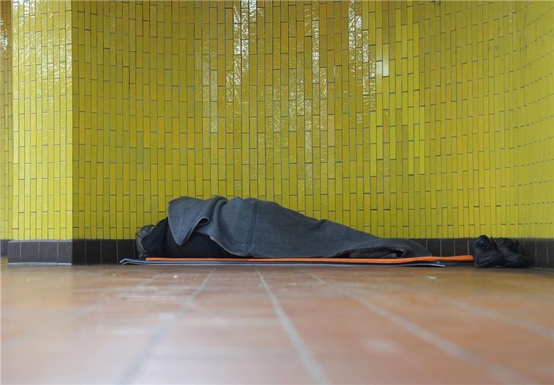 Ein Obdachloser liegt in seinem Schlafsack in einer U-Bahnstation in der Hamburger Innenstadt. 17,7 Millionen Menschen waren 2023 in Deutschland von Armut oder Ausgrenzung bedroht.