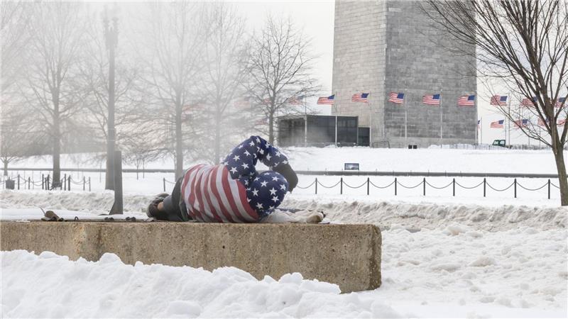 Ein Obdachloser ruht sich nach einem schweren Wintersturm in der Nähe des Washington Monuments auf.