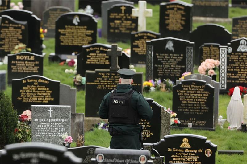 Nordirland: Polizei entdeckt mutmaßliche Rohrbomben Ein PSNI-Polizist patrouilliert auf dem Stadtfriedhof von Londonderry. Kurz vor der Ankunft von US-Präsident Biden in Nordirland fand die Polizei dort vier mutmaßliche Rohrbomben.
