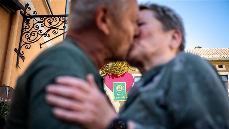 Ein Paar küsst sich an der Eisenberger „Kusshaltestelle“. 