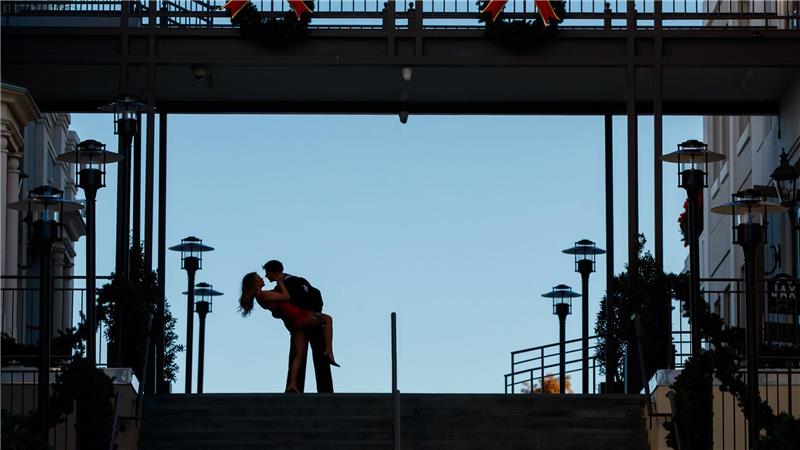 Ein Paar küsst sich an seinem einjährigen Hochzeitstag oben auf den Stufen der Jax Brewery im French Quarter von New Orleans.