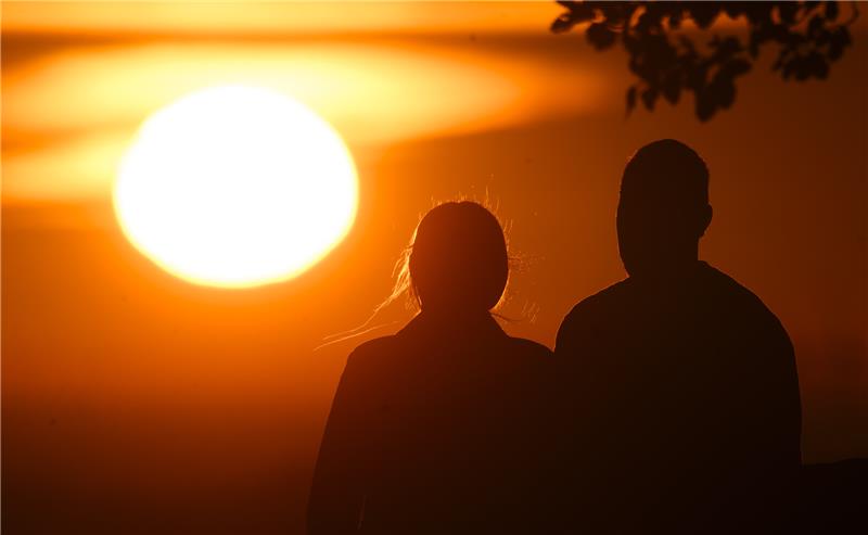 Wie Liebe unser Gehirn auf den Kopf stellt Ein Paar sitzt bei Sonnenaufgang auf dem Kronsberg in Hannover. Foto: Julian Stratenschulte/dpa