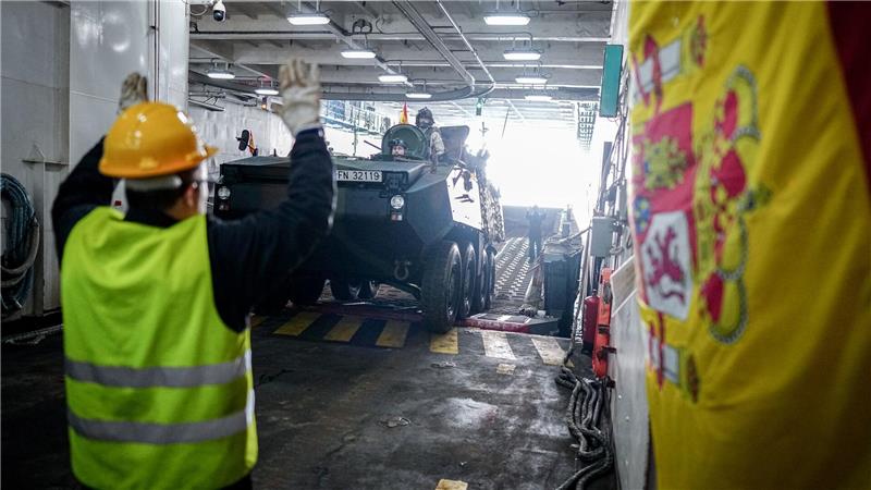 Ein Panzer wird vom Flagschiff auf ein Landeboot verladen. 
