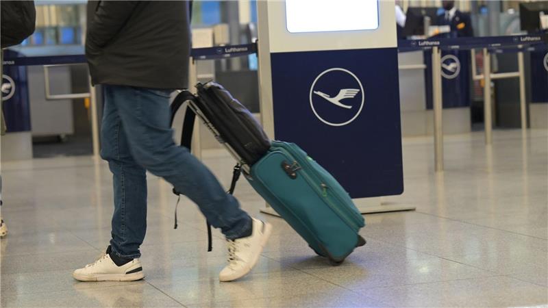 Ein Passagier läuft an einem Lufthansa-Schalter vorbei. Bei der Lufthansa gehen am Donnerstag Piloten und Flugbegleiter gleichzeitig in einen ganztägigen Streik.