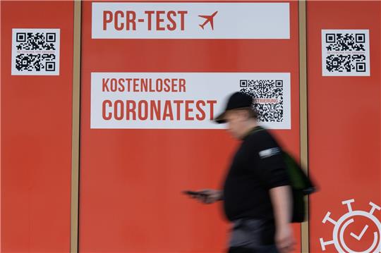 Ein Passant geht an einem Corona-Testcenter in Dresden entlang.